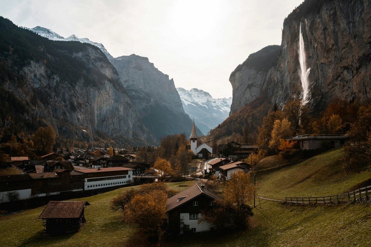 Lauterbrunnen valley with Staubbach Falls, chalets and snow-capped peaks in the Swiss Alps